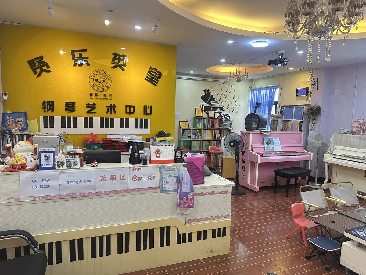 贤乐琴行前台接待区 - 黄色主题接待区配钢琴键盘前台和水晶吊灯